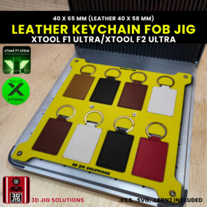 A top-down view of the xTool F1 Ultra Leather Keychain Jig securely holding four blank rectangular PU leather key fobs.